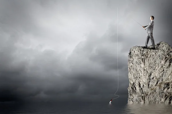 Businessman fishing with rod — Stock Photo, Image