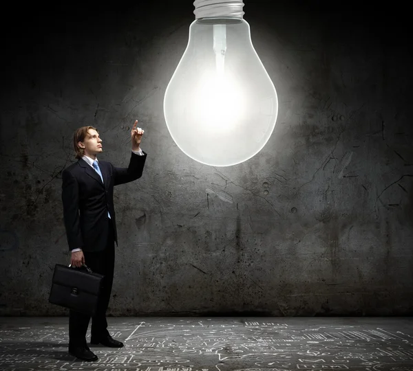 Affärsman och stor glödlampa — Stockfoto