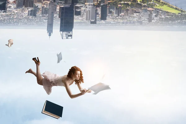 Young woman levitates while reading a book — Stock Photo, Image