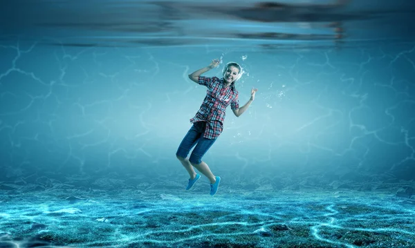 Γυναίκα που φοράει ακουστικά κάτω από το νερό. Μεικτά μέσα — Φωτογραφία Αρχείου