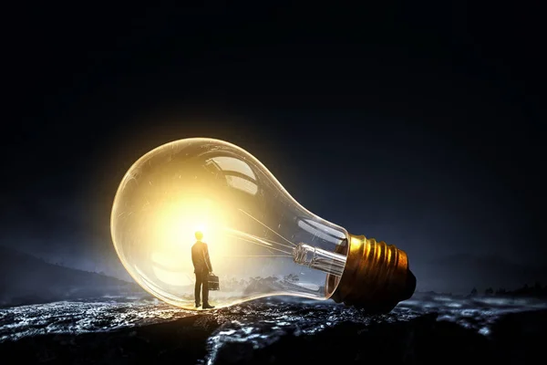 Huge light bulb glowing in the darkness — Stock Photo, Image