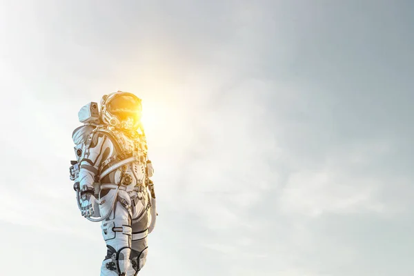 Astronauta contra el cielo nublado fondo —  Fotos de Stock