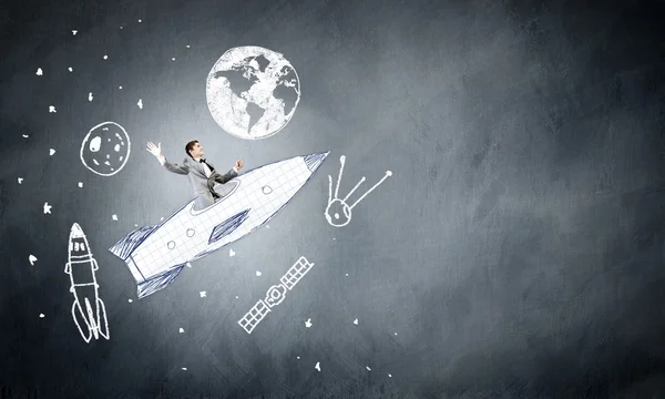 Businessman flying on drawn rocket — Stock Photo, Image
