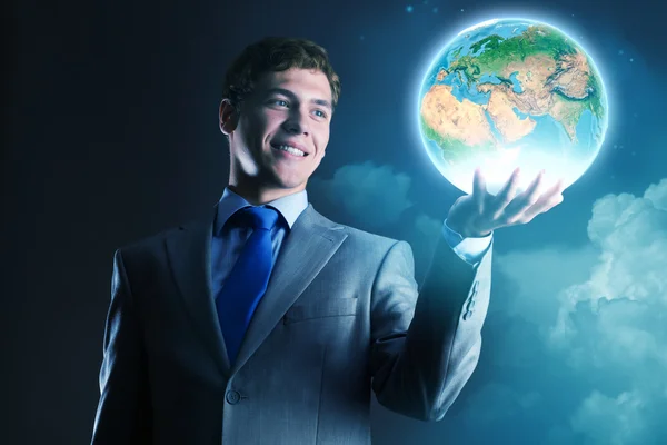 Affärsman som håller jorden planet i hand — Stockfoto
