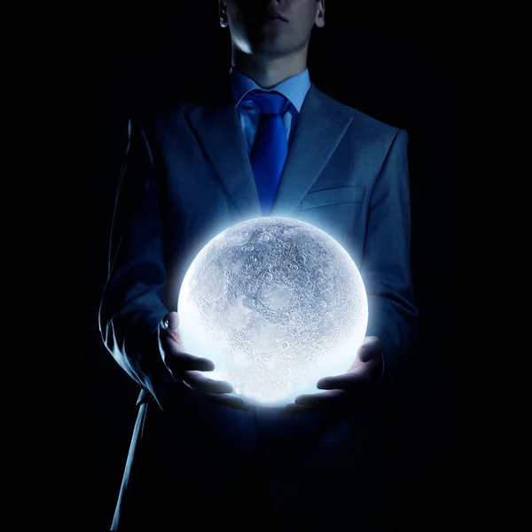 Affärsman håller månen planet — Stockfoto