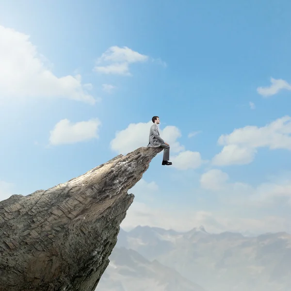 Businessman on edge of mountain rock — Stock Photo, Image