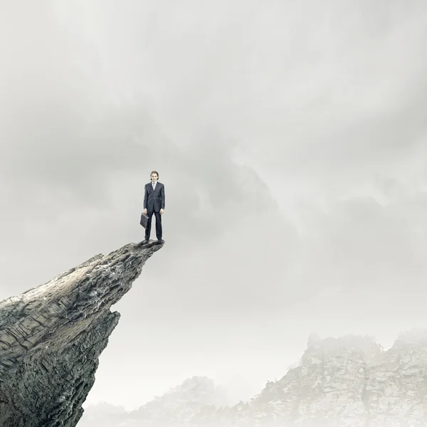 Бизнесмен, стоящий на краю скалы — стоковое фото