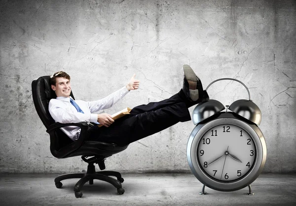 Businessman sitting in chair with cup — Stock Photo, Image