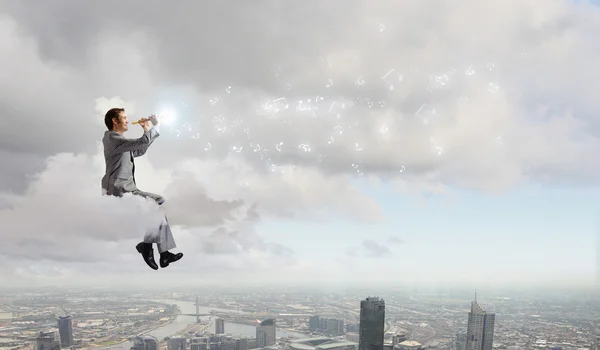 Empresario en la nube y tocando la flauta — Foto de Stock