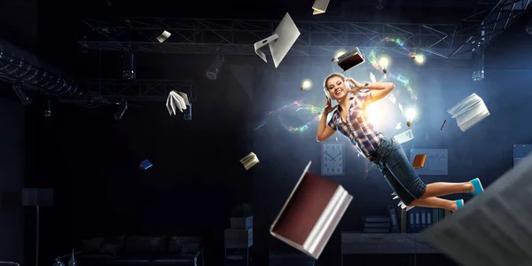 Woman wearing headphones jumping . Mixed media — Stock Photo, Image