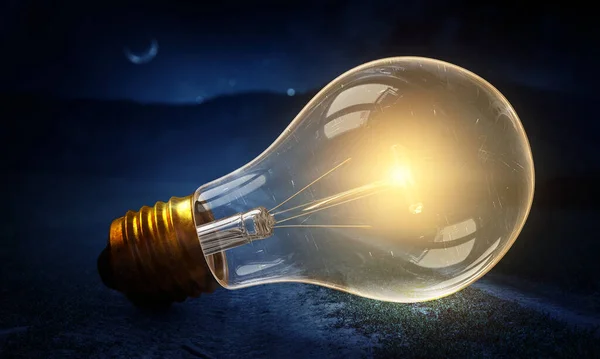 Huge light bulb glowing in the darkness — Stock Photo, Image