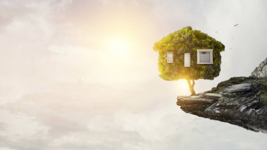 Yeşil çimlerin üzerindeki küçük Eco House. Karışık ortam