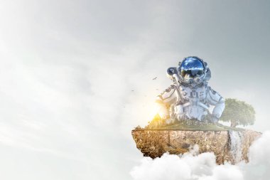 Bulutlu gökyüzü arkaplanına karşı astronot