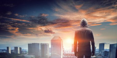 Kapüşonlu bir adamın silueti. Karışık ortam