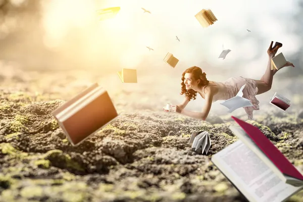 Jonge vrouw zweeft tijdens het lezen van een boek — Stockfoto