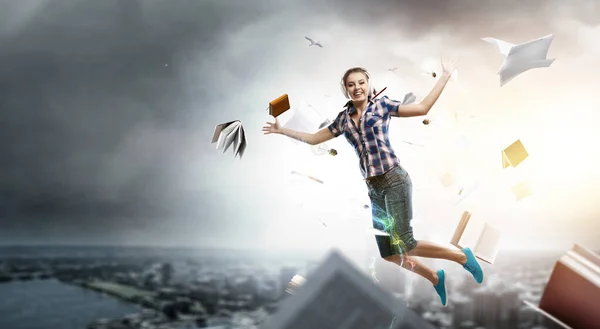 Woman wearing headphones jumping . Mixed media — Stock Photo, Image