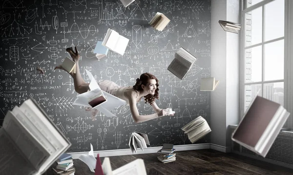 Genç bir kadın kitap okurken havada duruyor. — Stok fotoğraf
