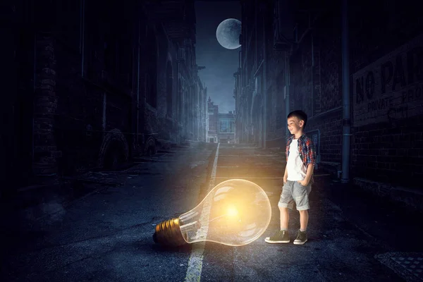 Мальчик с светящейся лампочкой — стоковое фото