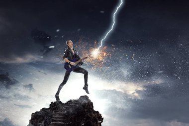 Elektro gitar çalan genç ve güzel bir rock kızı. Karışık ortam