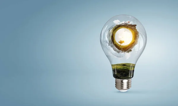 Green landscape inside light bulb — Stock Photo, Image