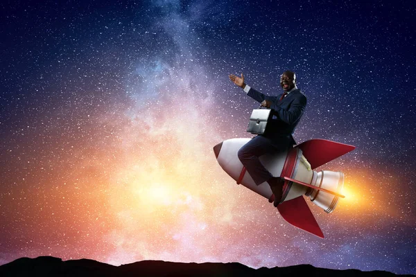 Businessman on a rocket . Mixed media — Stock Photo, Image