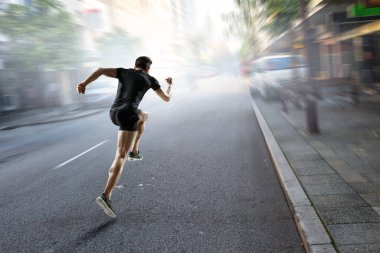 Spor giyimli bir adam koşuyor. Karışık ortam
