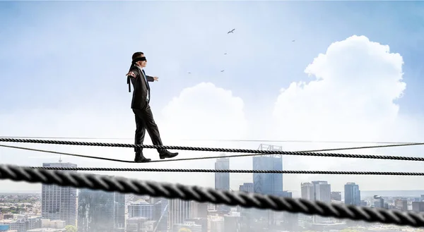 Beeld van een zakenman die balanceert op touw. Risicoconcept. Gemengde media — Stockfoto