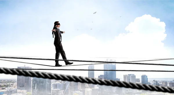 Imagen del hombre de negocios balanceándose en la cuerda. Concepto de riesgo. Medios mixtos — Foto de Stock