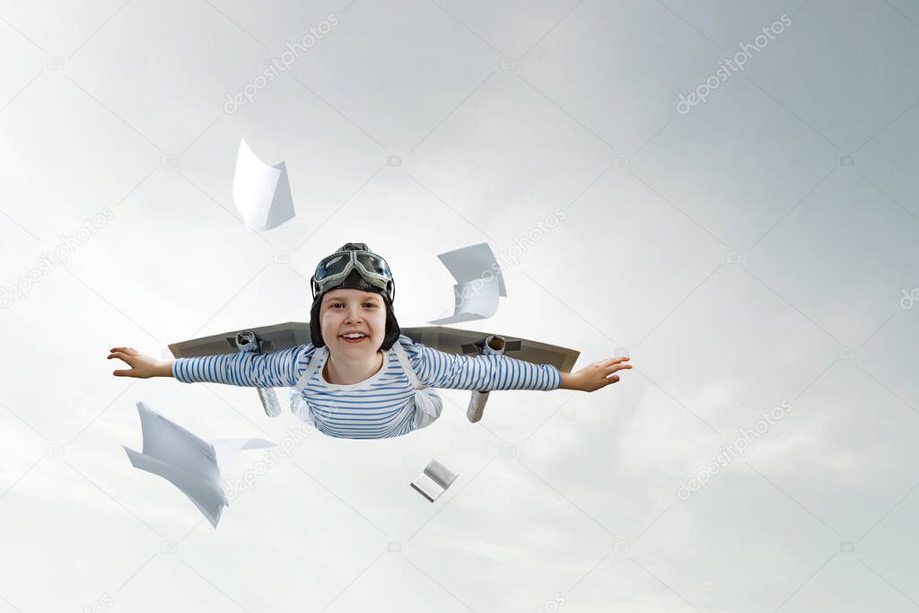 Happy little boy flying wearing helmet