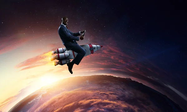 Businessman on a rocket . Mixed media — Stock Photo, Image