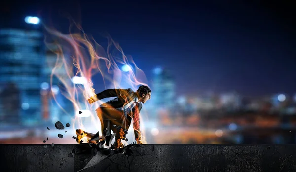 Determined businessman leaving fire trails on asphalt . Mixed media — Stock Photo, Image