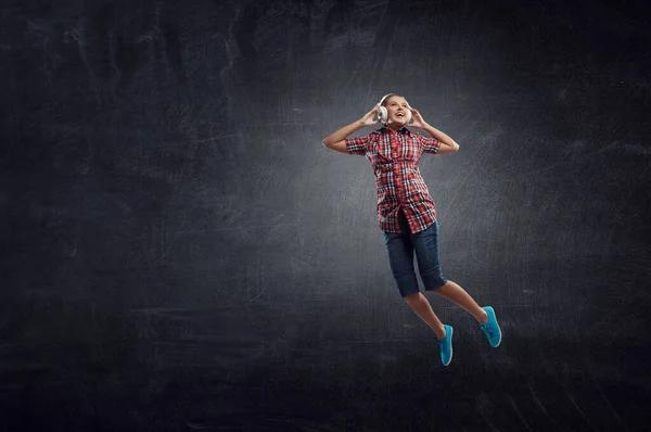 Kvinnan med hörlurar som hoppar. Blandade medier — Stockfoto