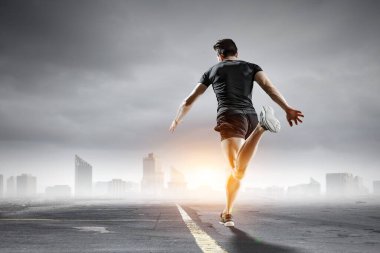 Spor giyimli bir adam koşuyor. Karışık ortam