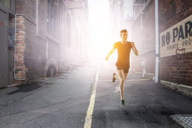 Spor giyimli bir adam koşuyor. Karışık ortam