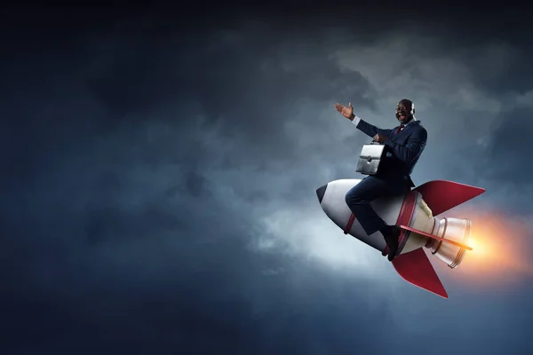 Businessman on a rocket . Mixed media — Stock Photo, Image