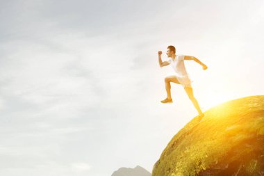 Spor giyimli bir adam koşuyor. Karışık ortam