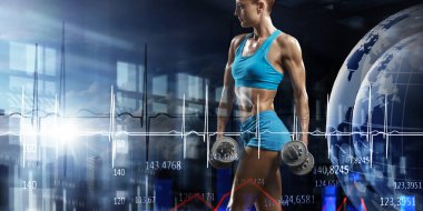 Genç ve güzel bir kız karanlık arka planda egzersiz yapıyor.