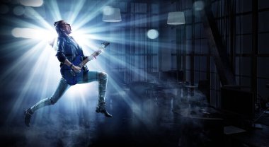 Genç ve güzel rock kızı elektro gitar çalıyor.