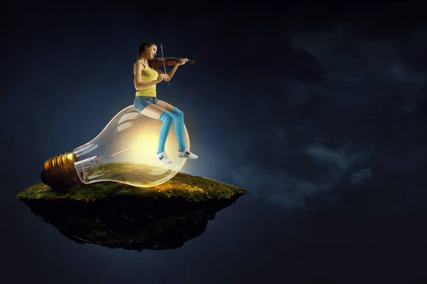 女孩坐在灯泡上拉小提琴 — 图库照片