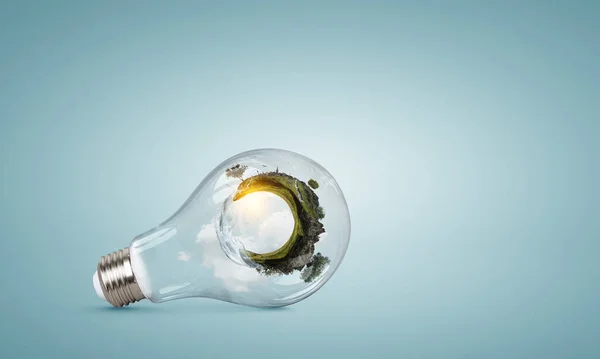 Green landscape inside light bulb — Stock Photo, Image