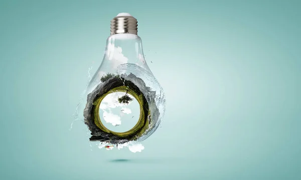 Green landscape inside light bulb — Stock Photo, Image