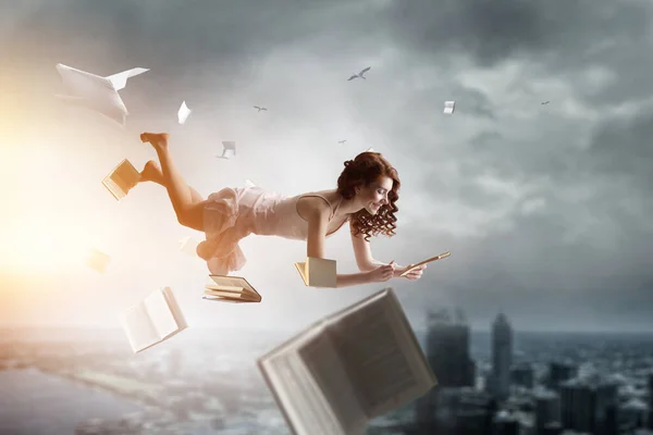 Young woman levitates while reading a book — Stock Photo, Image