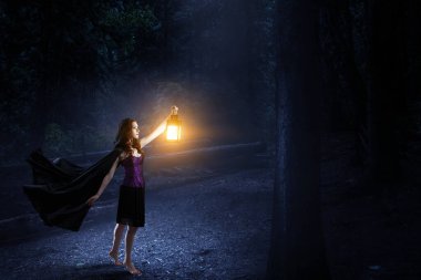 Cadı şapkası ve kostümü giymiş güzel bir kadın.