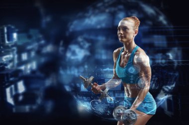 Genç ve güzel bir kız karanlık arka planda egzersiz yapıyor.