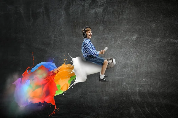 Kid wearing headphones on a rocket — Stock Photo, Image