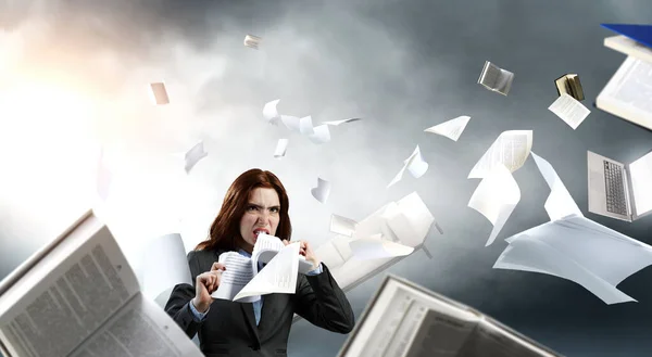Junge gestresste Frau zerreißt Dokumente mit frustriertem Gesichtsausdruck. — Stockfoto