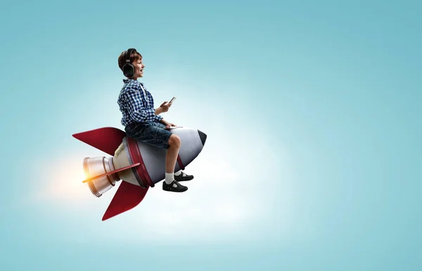 Kid wearing headphones on a rocket — Stockfoto
