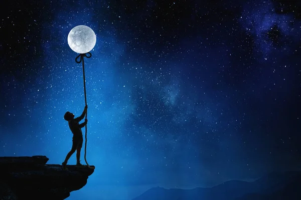 Chłopiec trzymający księżyc w nocy — Zdjęcie stockowe