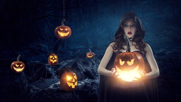 Cadı şapkası ve kostümü giymiş güzel bir kadın.