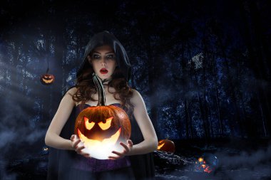 Cadı şapkası ve kostümü giymiş güzel bir kadın.